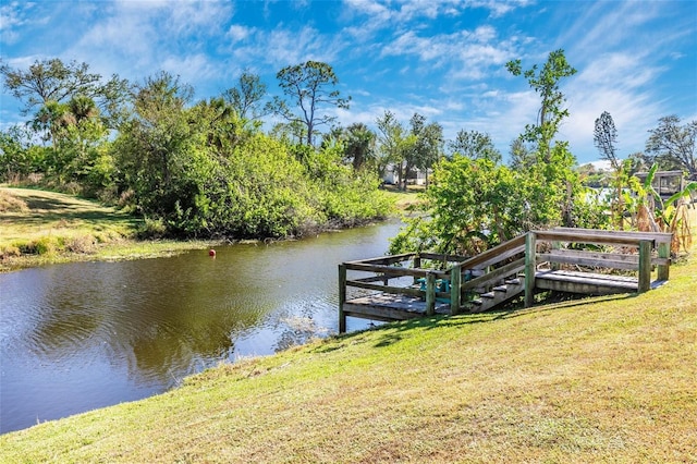 dock area with a water view and a lawn