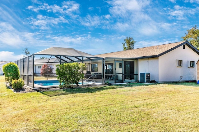 back of house featuring a lawn, glass enclosure, cooling unit, and a patio area