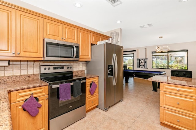 kitchen featuring light stone counters, billiards, decorative backsplash, light tile patterned floors, and appliances with stainless steel finishes