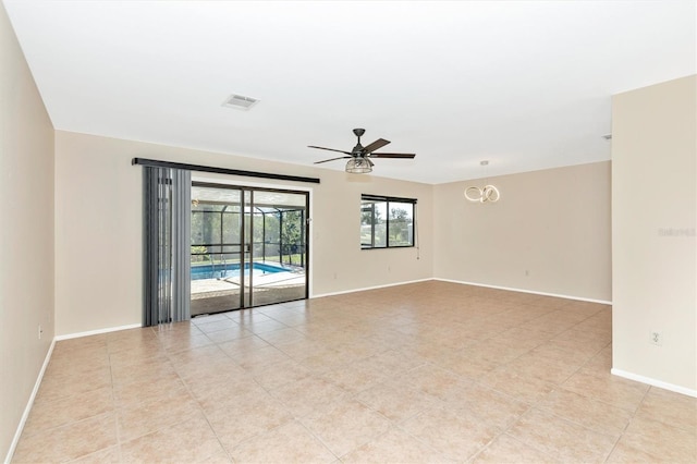 empty room featuring a ceiling fan, visible vents, and baseboards