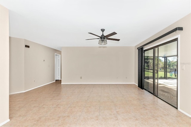 empty room featuring light tile patterned floors, visible vents, a ceiling fan, and baseboards