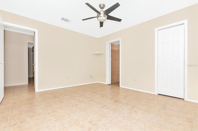 unfurnished bedroom featuring light tile patterned floors, baseboards, visible vents, and a ceiling fan