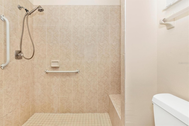 bathroom featuring a tile shower and toilet