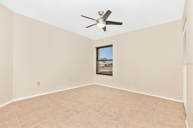 spare room featuring a ceiling fan and baseboards