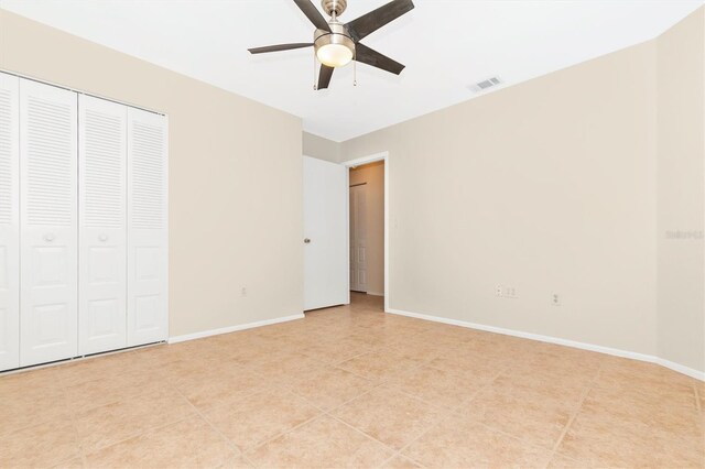 unfurnished bedroom with ceiling fan, a closet, visible vents, and baseboards