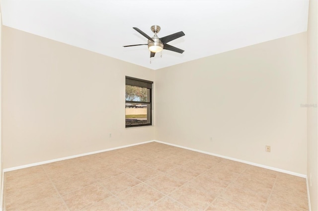 spare room with ceiling fan and baseboards