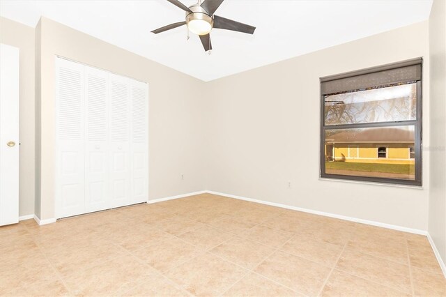 spare room with ceiling fan and baseboards