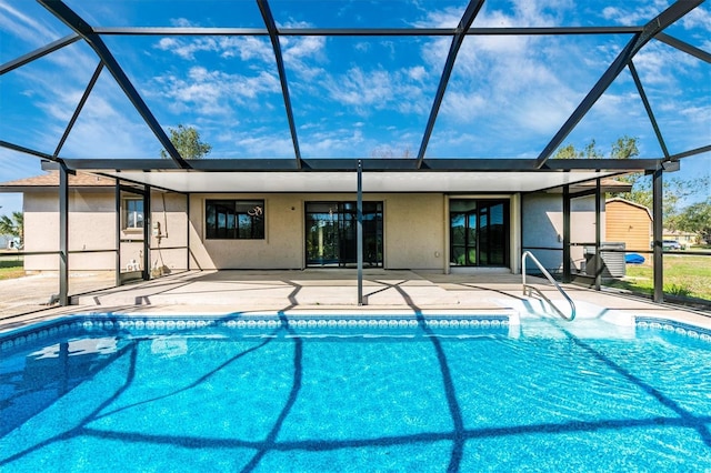 pool featuring glass enclosure and a patio