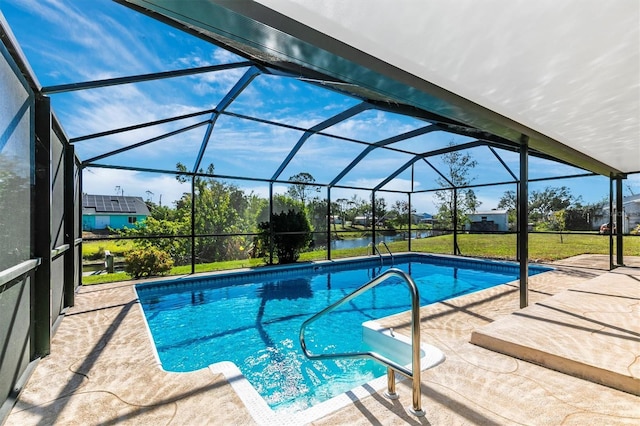 pool featuring a patio area, a lanai, a water view, and a lawn