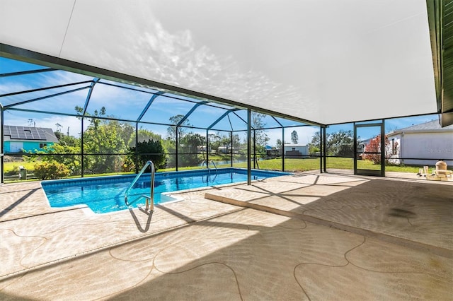 outdoor pool with glass enclosure, a patio, and a lawn