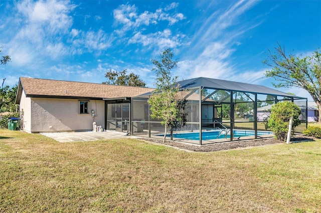 rear view of property with a yard, an outdoor pool, glass enclosure, and a patio