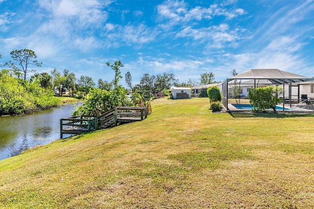 view of yard with a water view and glass enclosure