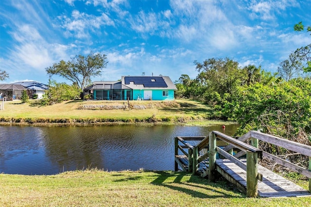 view of dock with a yard and a water view