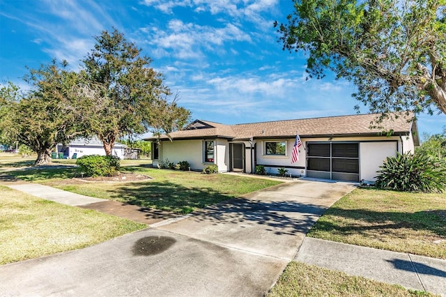 ranch-style home featuring concrete driveway, an attached garage, a front lawn, and stucco siding