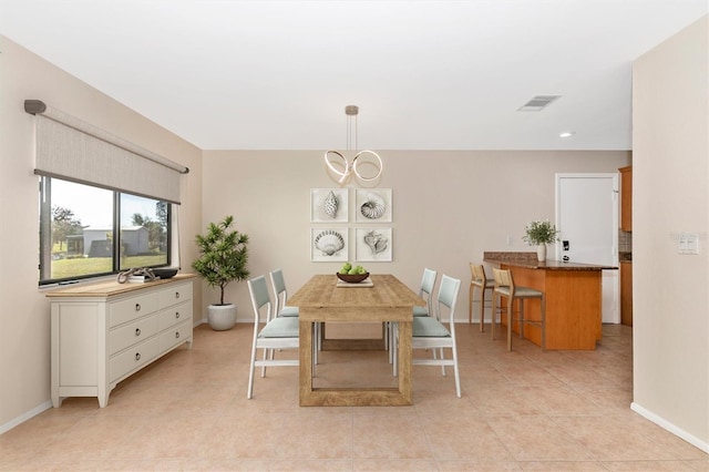 dining space with a notable chandelier, light tile patterned floors, visible vents, and baseboards