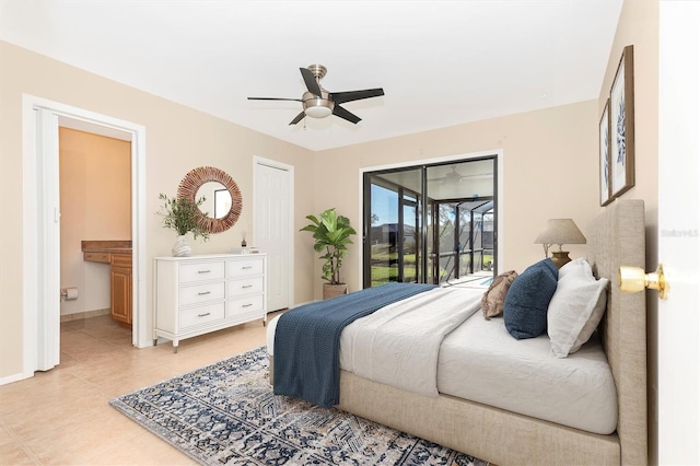 bedroom with ensuite bathroom, ceiling fan, light tile patterned flooring, baseboards, and access to exterior