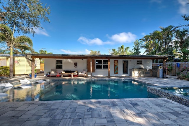 view of swimming pool with outdoor lounge area, exterior kitchen, and a patio