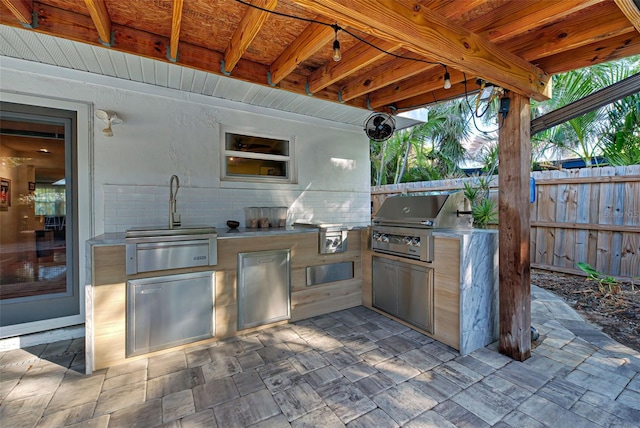 view of patio / terrace with grilling area, sink, and an outdoor kitchen