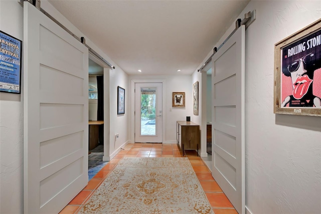 doorway with a barn door and light tile patterned flooring