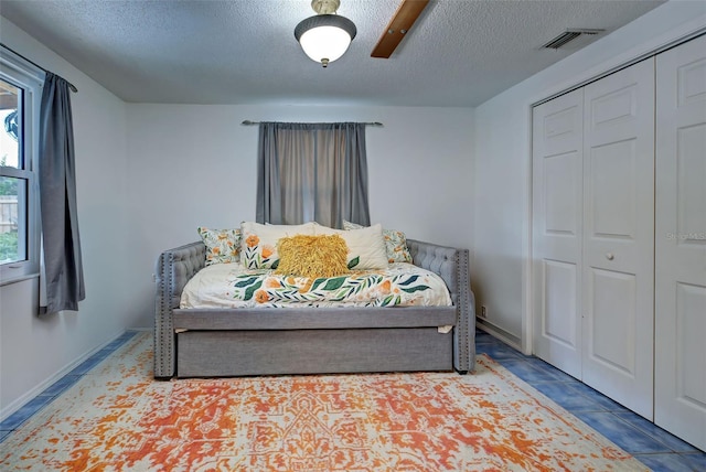 bedroom featuring a textured ceiling, a closet, and ceiling fan