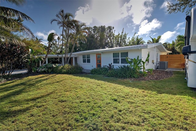 ranch-style home featuring a front lawn and central AC unit