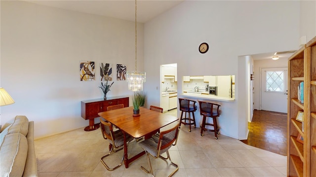 dining room with a towering ceiling, light hardwood / wood-style floors, and sink