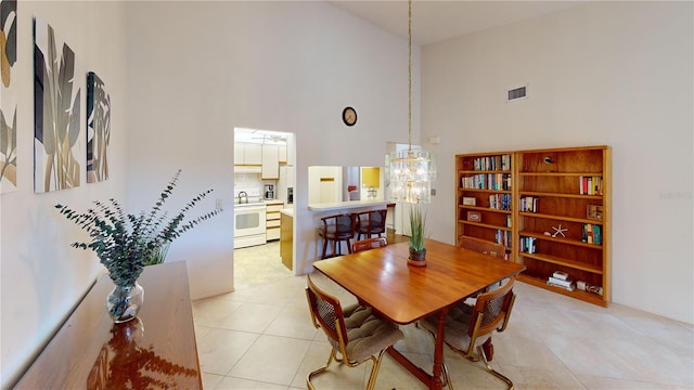 dining area featuring high vaulted ceiling, light tile patterned floors, and an inviting chandelier