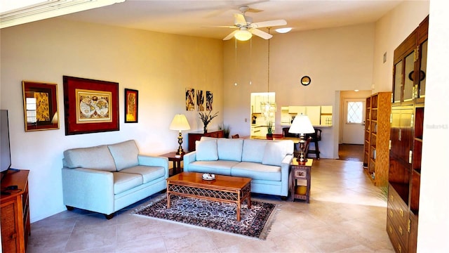 living room with ceiling fan and a high ceiling