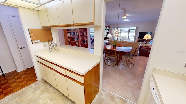 kitchen featuring ceiling fan with notable chandelier and light parquet flooring