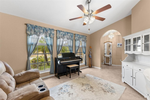 living area featuring ceiling fan, light tile patterned floors, and vaulted ceiling