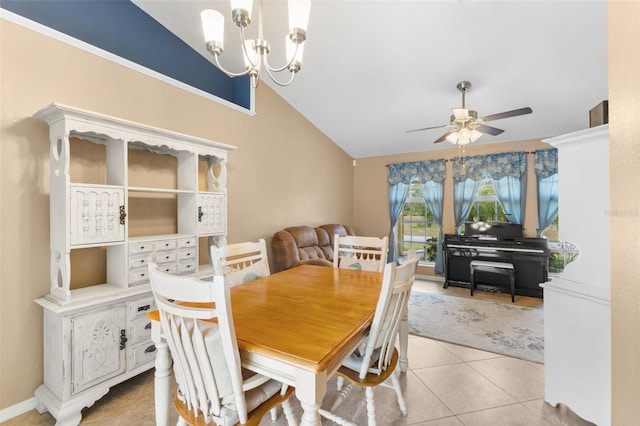 tiled dining space featuring ceiling fan with notable chandelier and vaulted ceiling