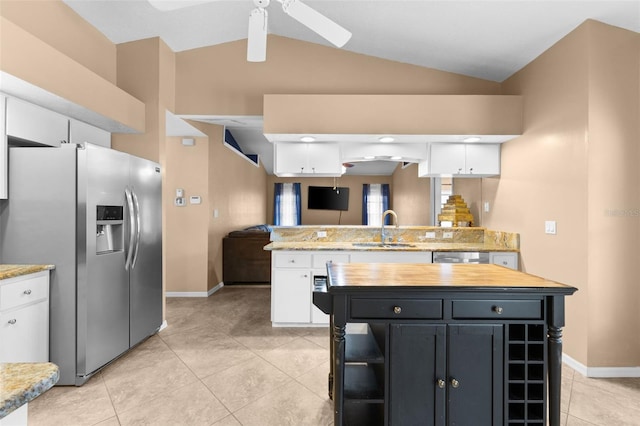 kitchen featuring appliances with stainless steel finishes, vaulted ceiling, sink, white cabinets, and a kitchen island