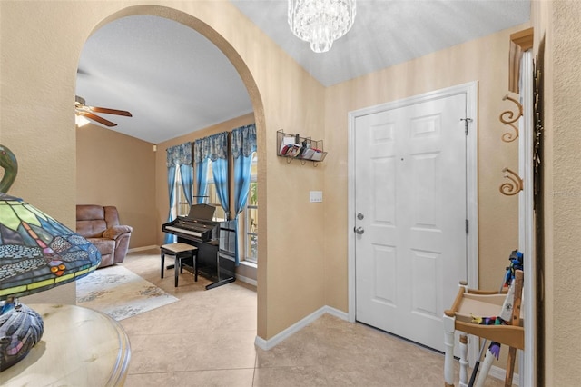 foyer entrance featuring ceiling fan with notable chandelier and light tile patterned flooring