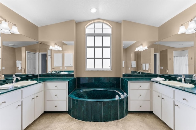 bathroom featuring a bathing tub, vanity, tile patterned floors, and vaulted ceiling