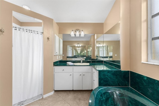 bathroom featuring tile patterned floors, a washtub, vanity, and a notable chandelier