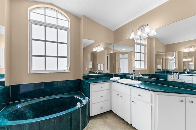 bathroom with a tub, a wealth of natural light, vanity, and vaulted ceiling