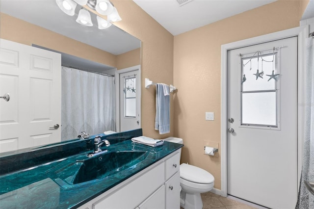 bathroom featuring tile patterned flooring, vanity, and toilet