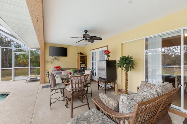 sunroom / solarium featuring ceiling fan and french doors