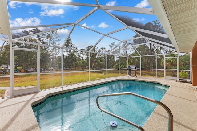 view of pool with glass enclosure, a yard, a patio, and grilling area