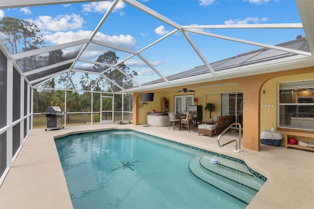 view of pool featuring glass enclosure, an outdoor hangout area, ceiling fan, area for grilling, and a patio