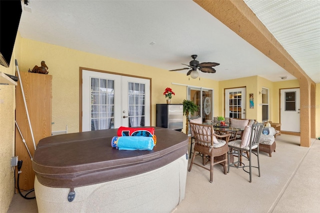 exterior space with french doors, light colored carpet, and ceiling fan