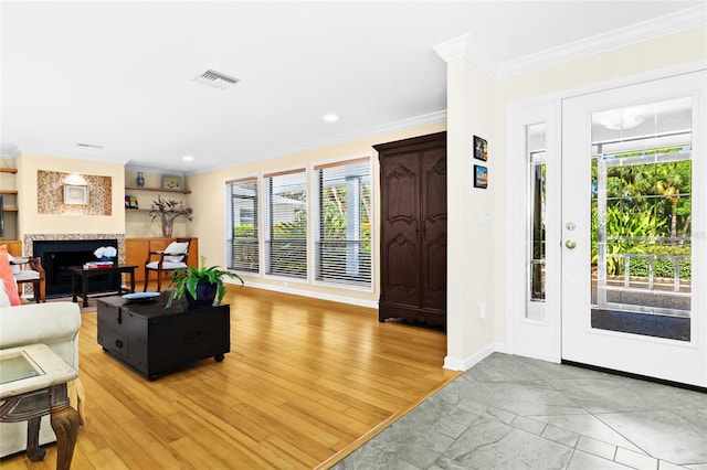 entryway with a healthy amount of sunlight, crown molding, and wood-type flooring