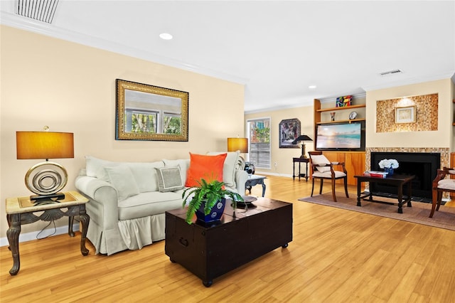 living room with crown molding and light hardwood / wood-style flooring