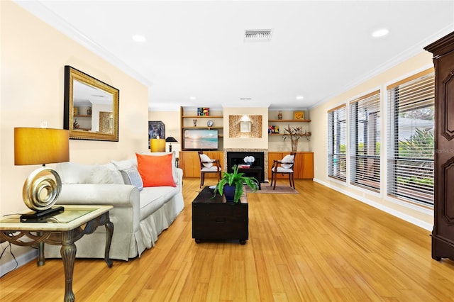 living room with a fireplace, light hardwood / wood-style floors, and crown molding