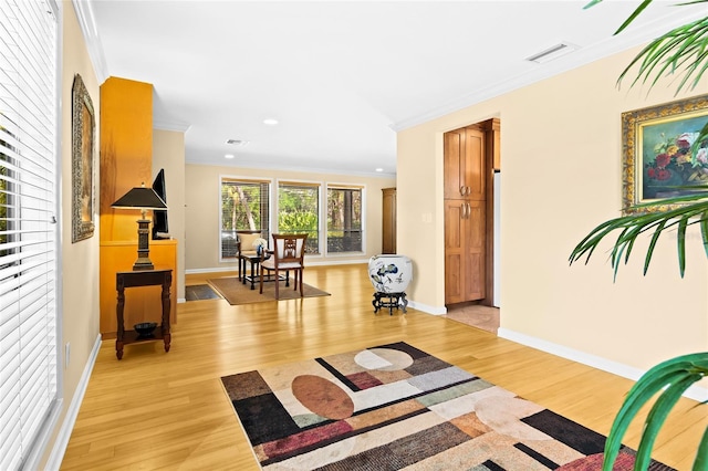 hall with light hardwood / wood-style floors and crown molding