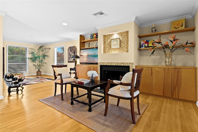 living area featuring ornamental molding and light wood-type flooring