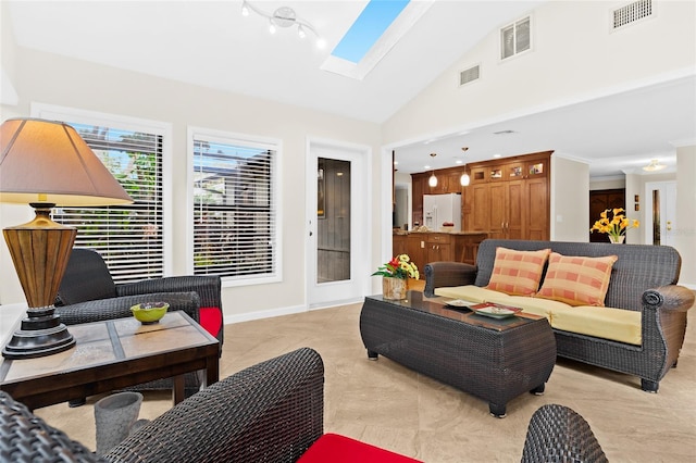 living room featuring light tile patterned floors, a skylight, and high vaulted ceiling