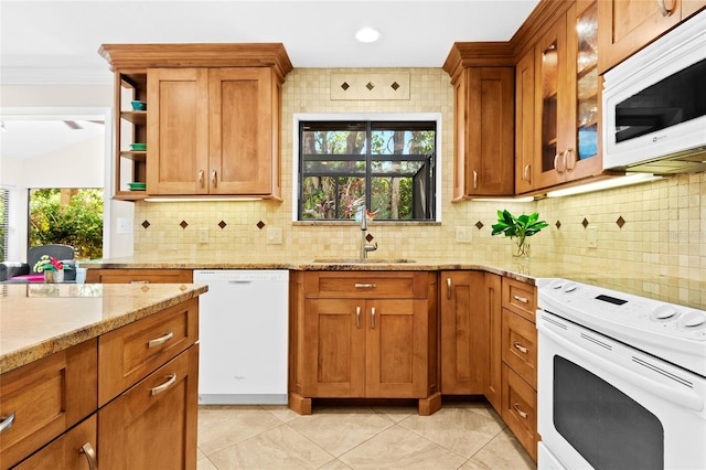 kitchen featuring plenty of natural light, tasteful backsplash, sink, and white appliances