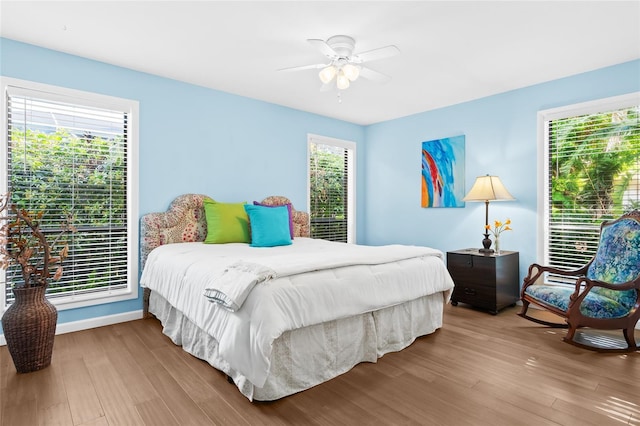 bedroom featuring multiple windows, ceiling fan, and hardwood / wood-style flooring