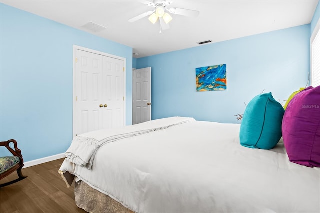 bedroom featuring ceiling fan, a closet, and dark wood-type flooring